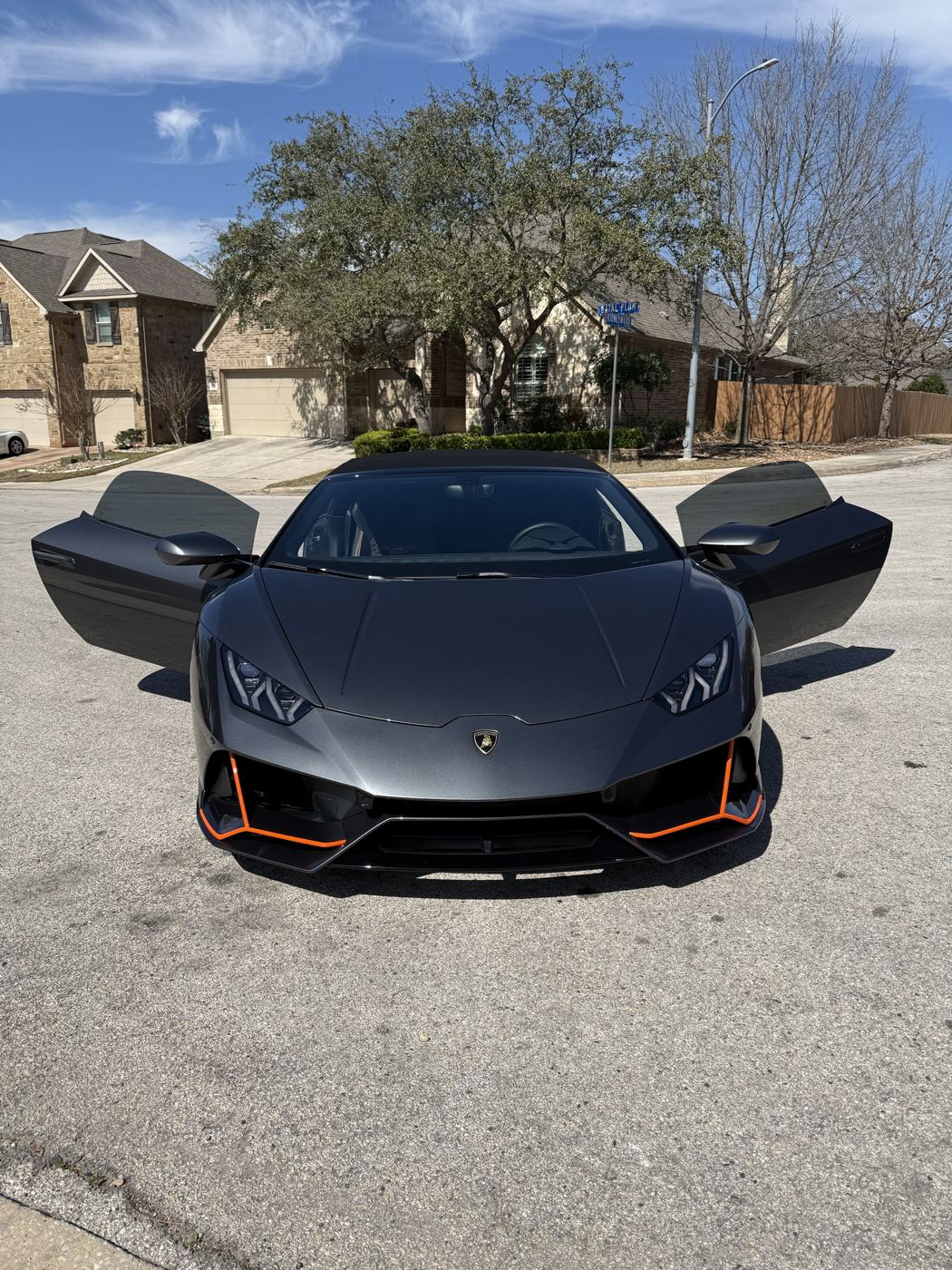 Gray Lamborghini Huracan Evo Spyder with doors open, front view, tinted windows