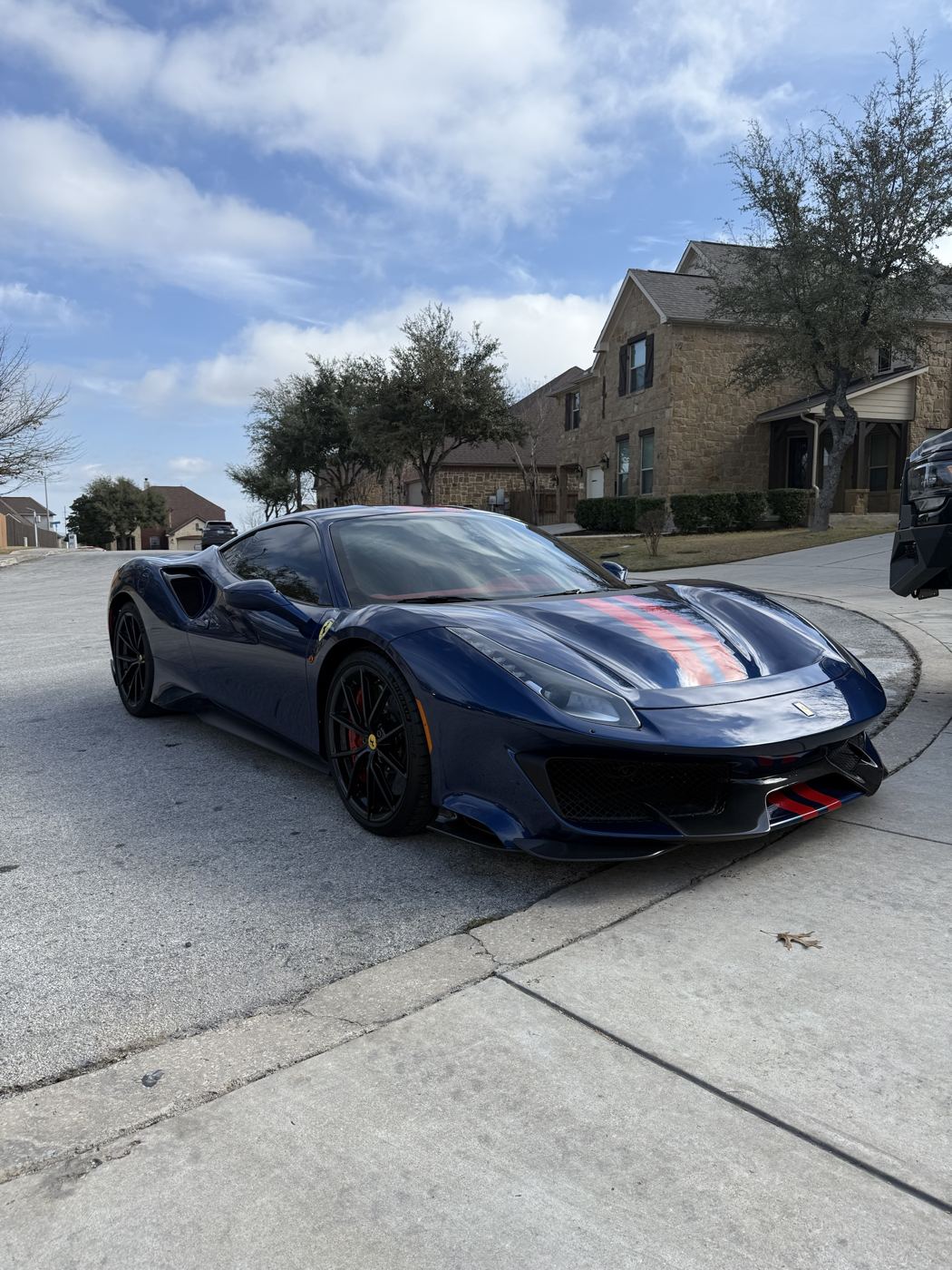 Blue Ferrari 488 Pista with red stripes, side view, tinted windows